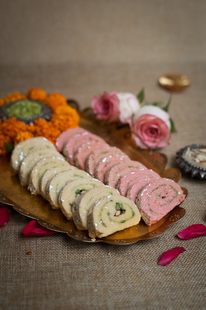 services-img Assorted Indian sweets displayed on a brass tray with flowers.