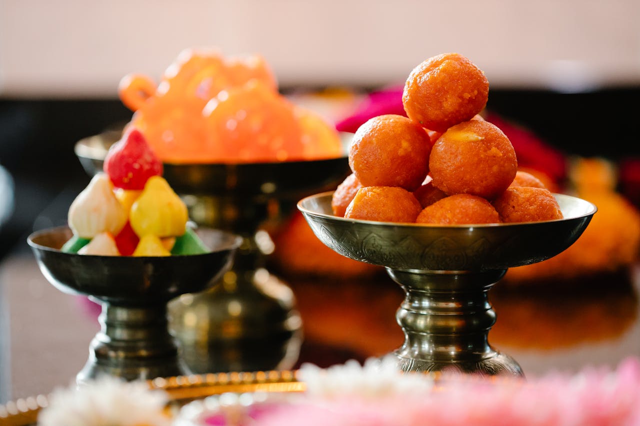 Close-up of traditional Indian sweets beautifully arranged in ornate bowls, highlighting vibrant colors.